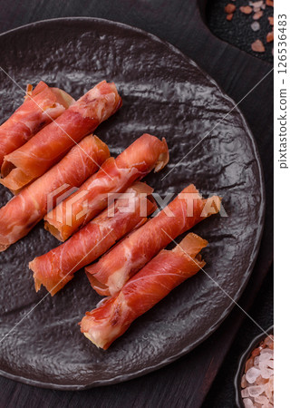 Cheese and meat, jamon or prosciutto rolled into a roll 126536483
