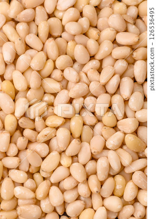 Peeled pine nuts in a bowl on a dark concrete background Peeled pine nuts in a bowl on a dark concrete background 126536495