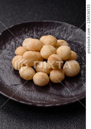 Raw peeled macadamia nut in ceramic bowl 126536535