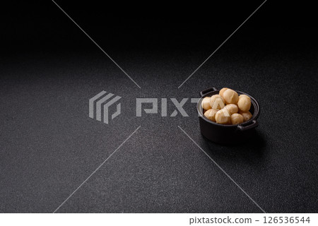 Raw peeled macadamia nut in ceramic bowl 126536544