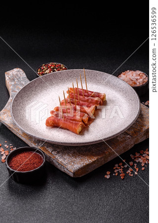 Cheese and meat, jamon or prosciutto rolled into a roll 126536599