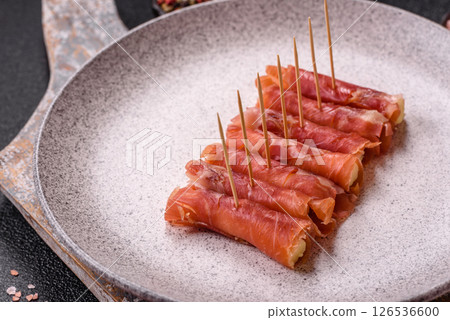 Cheese and meat, jamon or prosciutto rolled into a roll 126536600