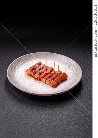 Cheese and meat, jamon or prosciutto rolled into a roll 126536611