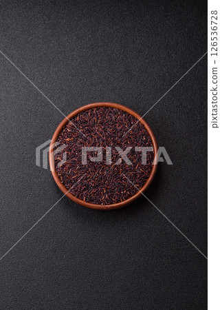Red or brown raw rice in a ceramic bowl 126536728