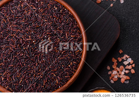 Red or brown raw rice in a ceramic bowl 126536735