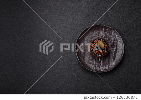 Sweet round tart with chocolate coating and nut filling 126536873