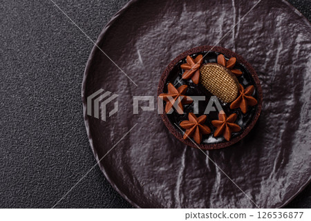 Sweet round tart with chocolate coating and nut filling 126536877