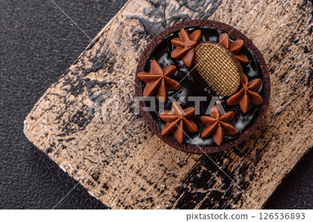 Sweet round tart with chocolate coating and nut filling Sweet round tart with chocolate coating and nut filling 126536893