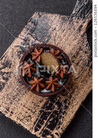 Sweet round tart with chocolate coating and nut filling 126536894