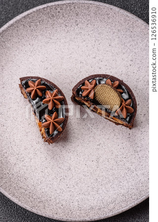 Sweet round tart with chocolate coating and nut filling 126536910