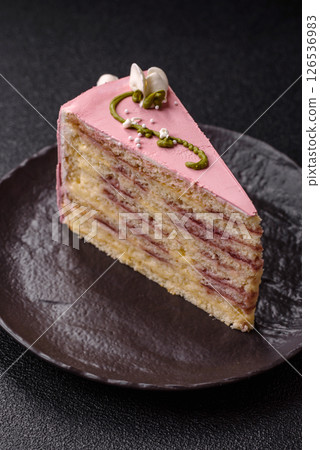 A piece of pink layered cake with strawberry flavor 126536983