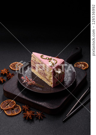 A piece of pink layered cake with strawberry flavor 126536992