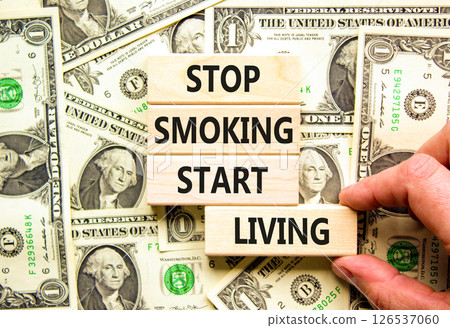 Stop smoking start living symbol. Concept words Stop smoking start living on cubes. Beautiful background from dollar bills. Doctor hand. Medical healthy stop smoking start living concept. Copy space. Stop smoking start living symbol. Concept words Stop smoking start living on cubes. Beautiful background from dollar bills. Doctor hand. Medical healthy stop smoking start living concept. Copy space. 126537060