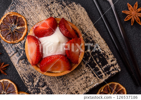 Round sweet tart with strawberry pieces and cream 126537186
