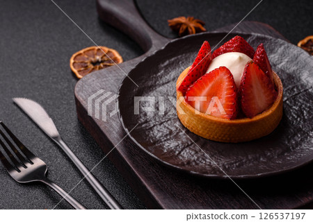 Round sweet tart with strawberry pieces and cream 126537197