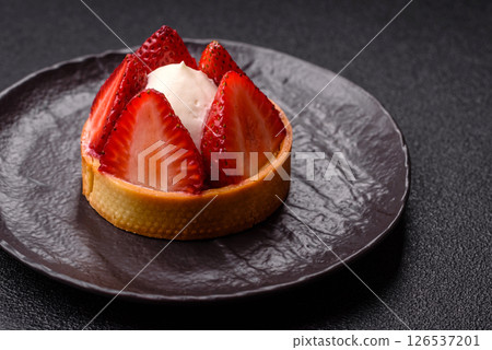 Round sweet tart with strawberry pieces and cream 126537201