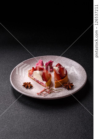 Round sweet tart with strawberry pieces and cream Round sweet tart with strawberry pieces and cream 126537211