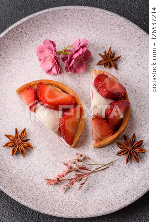Round sweet tart with strawberry pieces and cream 126537214