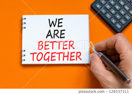 We are better together symbol. Concept words phrase We are better together on beautiful white note. Businessman's hand. Beautiful orange background. Business We are better together concept. Copy space We are better together symbol. Concept words phrase We are better together on beautiful white note. Businessman's hand. Beautiful orange background. Business We are better together concept. Copy space 126537311