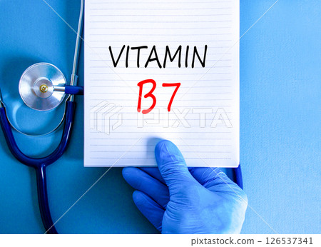 Vitamin B7 biotin symbol. Concept words Vitamin B7 on beautiful white note. Doctor's hand in blue medical glove. Stethoscope. Beautiful blue background. Medical healthy lifestyle Vitamin B7 concept. Vitamin B7 biotin symbol. Concept words Vitamin B7 on beautiful white note. Doctor's hand in blue medical glove. Stethoscope. Beautiful blue background. Medical healthy lifestyle Vitamin B7 concept. 126537341