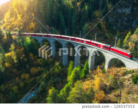 Aerial view of red train on Landwasser viaduct in autumn in Alps 126537353