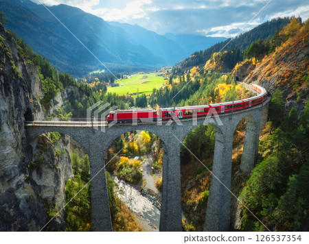 Aerial view of red train on Landwasser viaduct in autumn in Alps 126537354