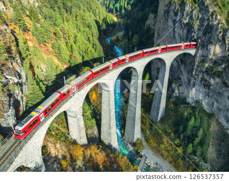 Aerial view of red train on Landwasser viaduct in autumn in Alps 126537357