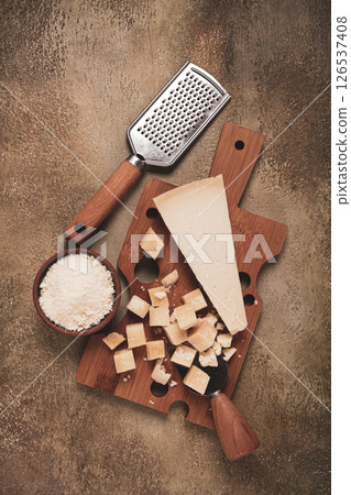 Freshly sliced and grated cheese, parmesan cheese, on a wooden chopping board, rustic style, no people Freshly sliced and grated cheese, parmesan cheese, on a wooden chopping board, rustic style, no people 126537408