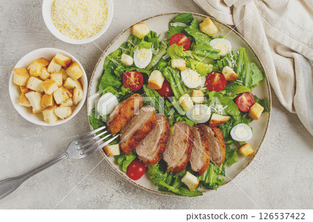 Caesar salad, with duck breast, on a light plate, on a light background, homemade, no people, 126537422