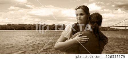 Insincere smile of a hugging girl 126537679