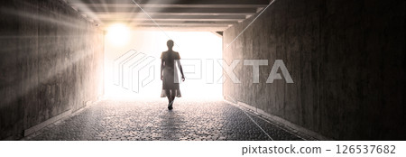 A woman emerges from a tunnel into the light 126537682