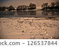 Snowy riverbank with frozen reflections 126537844