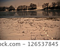 Snowy riverbank with frozen reflections 126537845