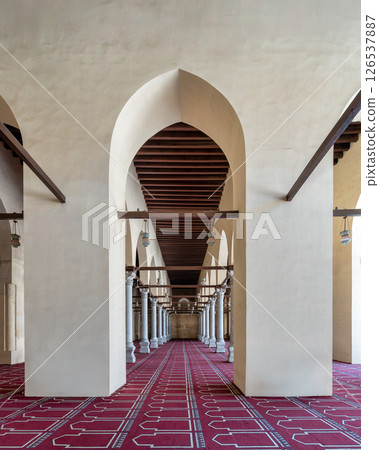 Historic mosque of al-Zahir Baybars features intricate columns and a vibrant prayer carpet in Cairo, Egypt 126537887