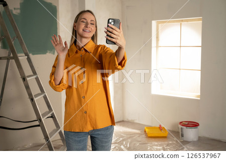 Architect woman video calling and waving during home renovation Architect woman video calling and waving during home renovation 126537967