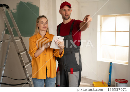 Foreman showing to architect using tablet during apartment renovation Foreman showing to architect using tablet during apartment renovation 126537971