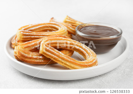 Traditional spanish dessert churros, fried dough pastry and chocolate sause on white background 126538333