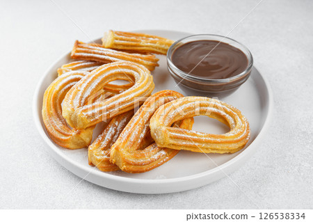 Traditional spanish dessert churros, fried dough pastry and chocolate sause on white background 126538334