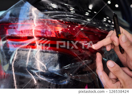 Applying a Protective Film on the Surface of Your Car for Enhanced Durability and Shine Applying a Protective Film on the Surface of Your Car for Enhanced Durability and Shine 126538424