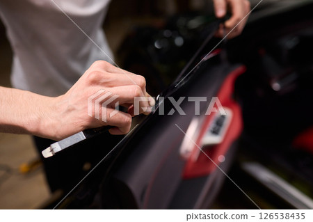 The Professional Windshield Tinting Process Conducted in a Modern Auto Showroom Environment 126538435