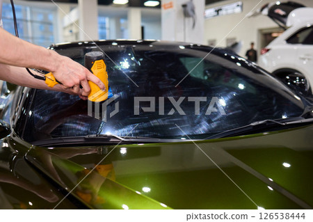The Professional Windshield Tinting Process Conducted in a Modern Auto Showroom Environment 126538444