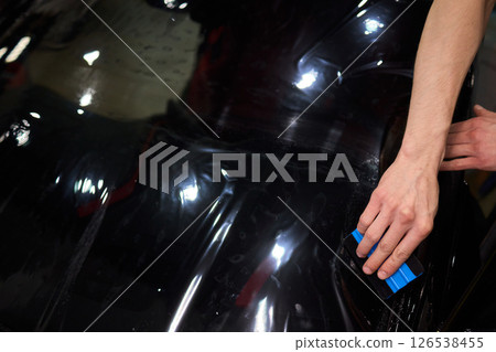 The Professional Windshield Tinting Process Conducted in a Modern Auto Showroom Environment The Professional Windshield Tinting Process Conducted in a Modern Auto Showroom Environment 126538455