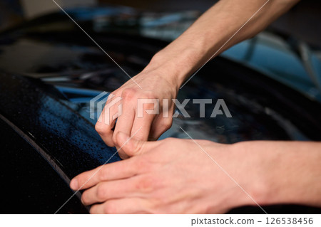 The Professional Windshield Tinting Process Conducted in a Modern Auto Showroom Environment The Professional Windshield Tinting Process Conducted in a Modern Auto Showroom Environment 126538456