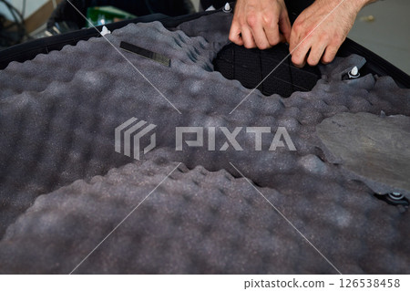 Hands Skillfully Engaged in the Construction of an Acoustic Foam Structure and Installation Hands Skillfully Engaged in the Construction of an Acoustic Foam Structure and Installation 126538458