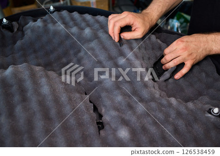 Hands Skillfully Engaged in the Construction of an Acoustic Foam Structure and Installation Hands Skillfully Engaged in the Construction of an Acoustic Foam Structure and Installation 126538459