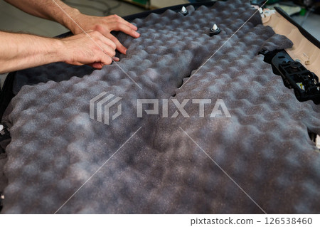 Hands Skillfully Engaged in the Construction of an Acoustic Foam Structure and Installation Hands Skillfully Engaged in the Construction of an Acoustic Foam Structure and Installation 126538460