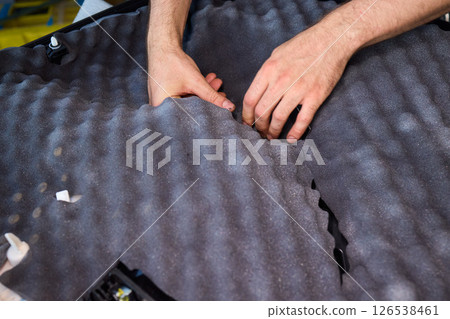 Hands Skillfully Engaged in the Construction of an Acoustic Foam Structure and Installation Hands Skillfully Engaged in the Construction of an Acoustic Foam Structure and Installation 126538461