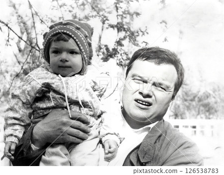 Vintage portrait of a man with a little girl on his shoulders. Dad with his daughter on a walk. Retro photo 1995. 126538783