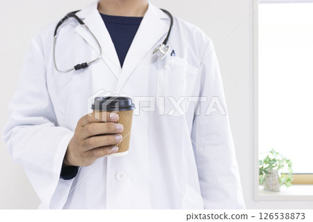 Image of a doctor holding a paper cup of coffee (Japanese, male, no face, 30s) Image of a doctor holding a paper cup of coffee (Japanese, male, no face, 30s) 126538873