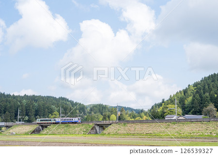 [Hokuhoku Line] A local train running through an embankment section 126539327
